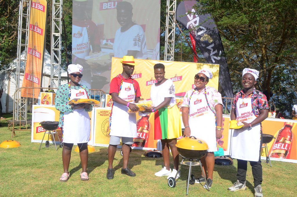 Matilda Babuleka Bell Lager Brand Manager c hands over a prize to one of the participants in the cook off