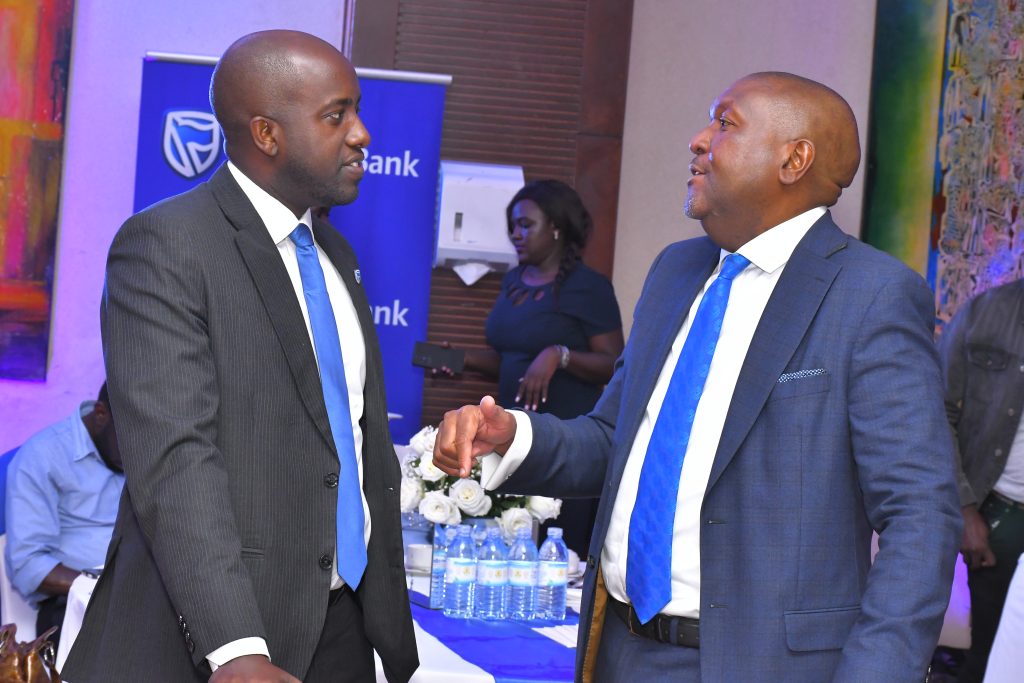 PHOTO 02 Andrew Mashanda right chats with Spencer Sabiiti Chief Executive for Stanbic Properties Limited during the official release of the 2022 financial results in Kampala on March 29