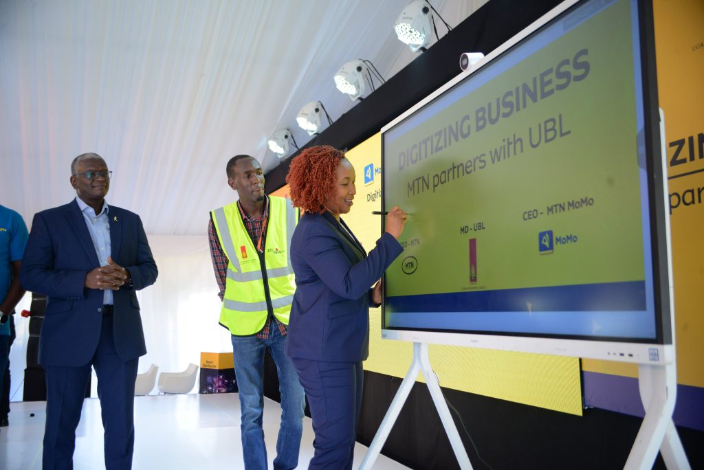 MTN Uganda CEO Sylvia Mulinge appends a digital signature to mark the launch of FMCG Digital Suite at Uganda Breweries Ltd on July 14. Lookking on is UBL MD Andrew Kilonzo. 1