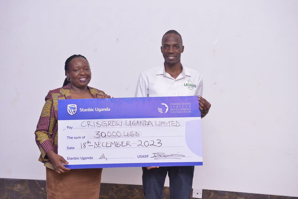 Emma Mugisha left the Executive Director and Head of Business Banking at Stanbic Bank handing over a dummy cheque to a representative of Crisgrow Uganda Limited