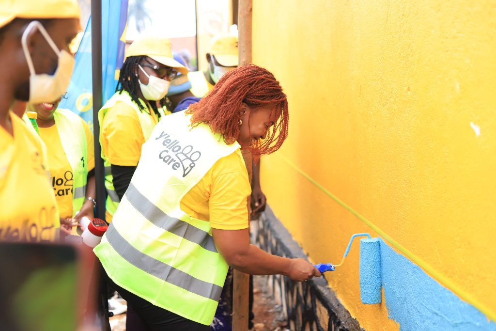 MTN Uganda CEO Sylvia Mulinge paints premises of Disability Employment Link Project Uganda located in Bwaise Kampala as part of MTNS 21 Days of Yello Care